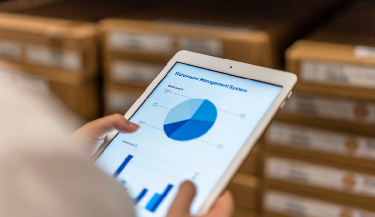 Over the shoulder view of a tablet showing a page labelled 'Warehouse Management System'