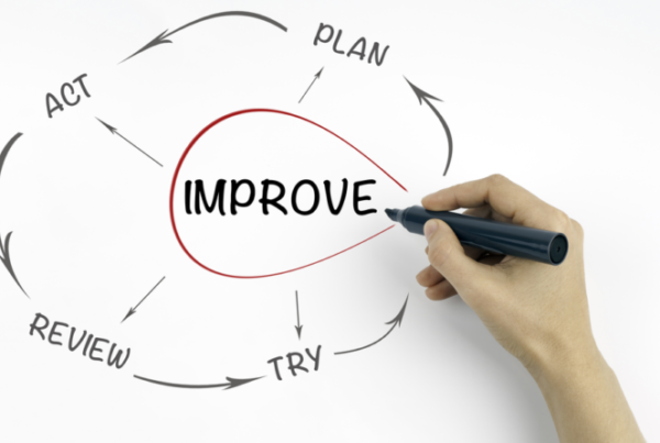 A person writing the word 'improve' on a whiteboard